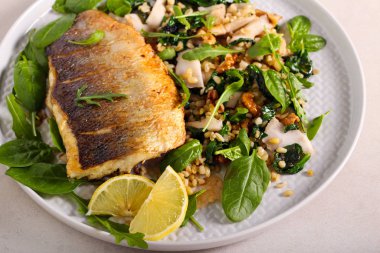 Kızarmış deniz levreği ve salata. 