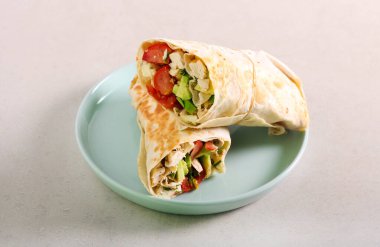 Tavuk, avokado ve domates rulosu, tabakta.