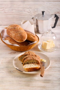 Ev yapımı kepekli ekmek karışık tohum dilimlenmiş ve tereyağıyla servis edilmiş.