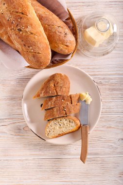 Ev yapımı kepekli ekmek karışık tohum dilimlenmiş ve tereyağıyla servis edilmiş.