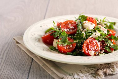 Domates, feta, roket ve tohum salatası.