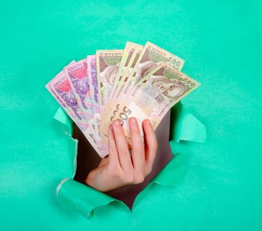 Yeşil kağıt üzerinde Ukrayna banknotlarını tutan