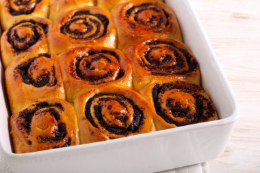 Taze pişmiş haşhaş tohumu teneke kutuda doluyor.