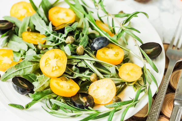 Свіжий зелений салат з руколою, жовті помідори, оливки, виноград — стокове фото