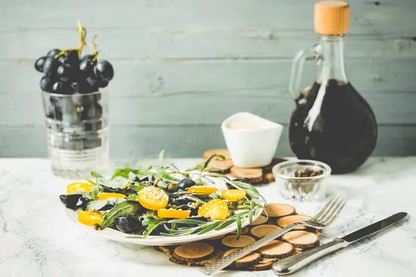 Зелений салат з руколою, жовтими помідорами, оливками та кунжутом, пін — стокове фото