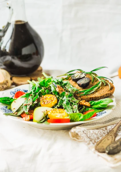 Ensalada con rúcula, pera, tomate, aceitunas, uvas, nueces y se — Foto de Stock