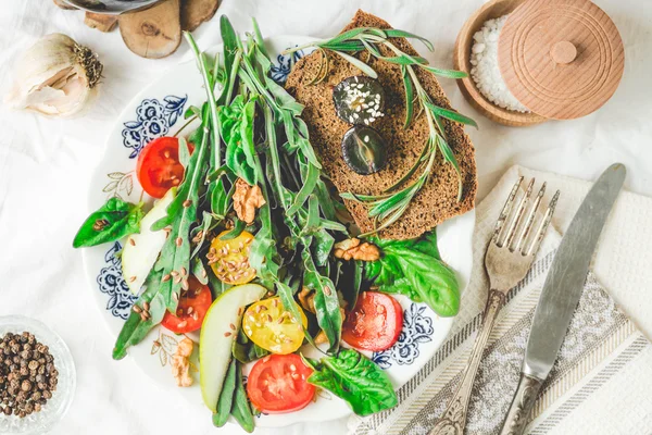 Salad with arugula, tomato, olives, grapes, walnuts, tinting — Stock Photo, Image