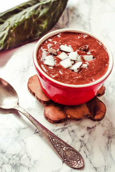 Chocolate pudding in a red bowl, with coconut,berries and chia s — Stock Photo, Image