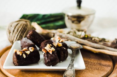 Ceviz üzerinde beyaz bir kare pla ile sağlıklı çiğ çikolata şekerleme