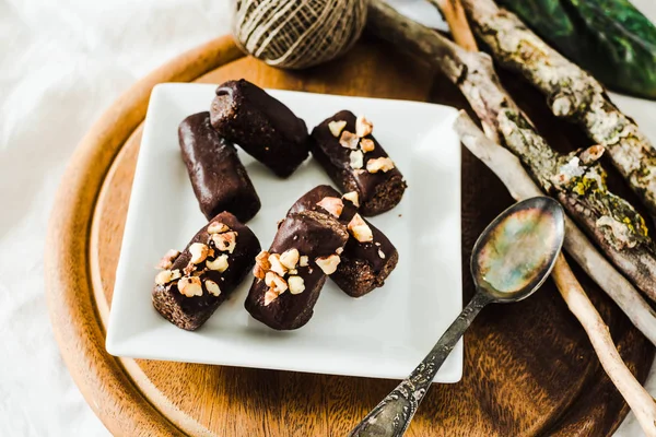 Zdrowe surowego cukierki czekoladowe z orzechami na biały kwadrat pla — Zdjęcie stockowe