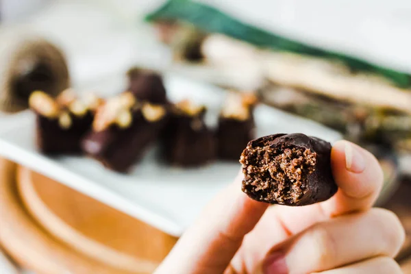 Dulces de chocolate crudo saludable con nueces en un pla cuadrado blanco — Foto de Stock