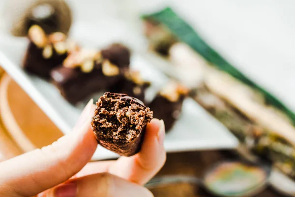 Dulces de chocolate crudo saludable con nueces en un pla cuadrado blanco — Foto de Stock