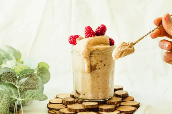 Derrite helado de plátano de chocolate vegano crudo con frambuesas en un — Foto de Stock