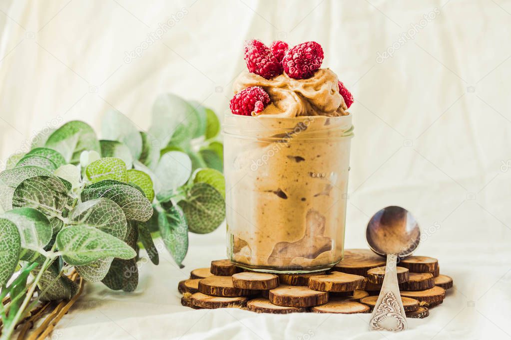 Healthy chocolate banana ice cream, raspberries in a glass jar