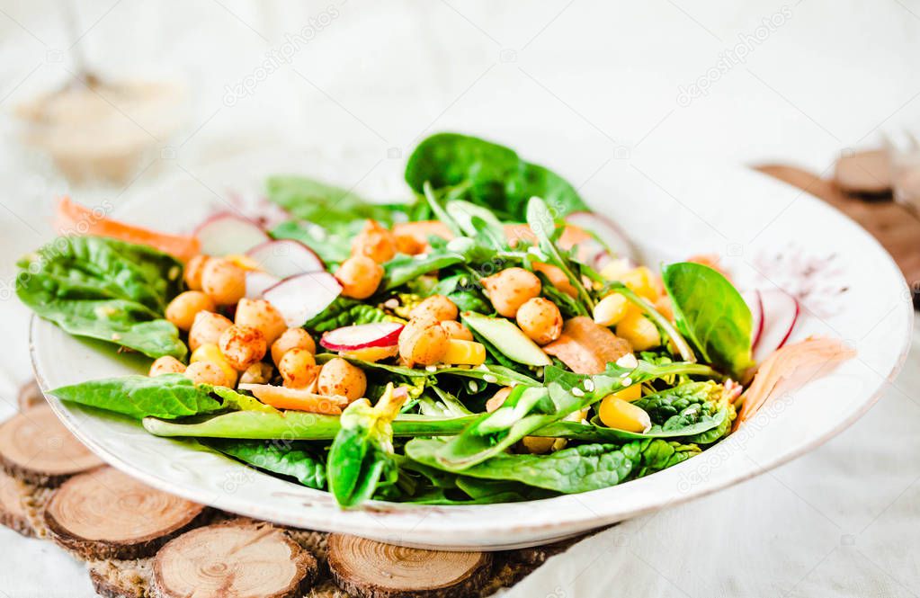 Green salad with arugula, corn, carrots and baked chickpeas.Heal