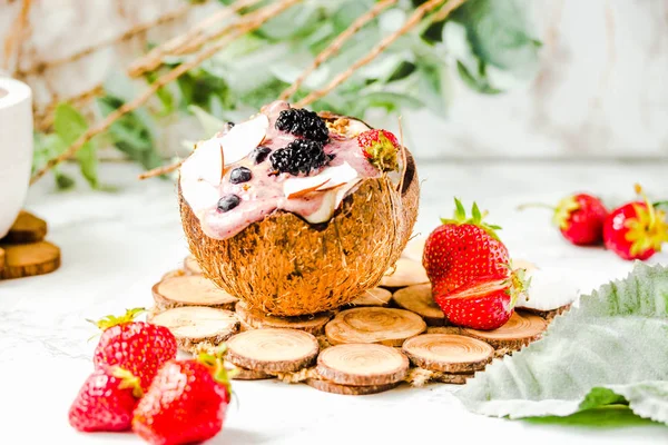 Berry smoothie with peanut butter and strawberry sauce in a coco