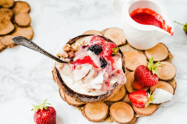 Smoothie aux baies avec beurre d'arachide et sauce aux fraises dans un coco — Photo