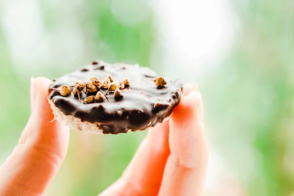 Dulces de coco caseros en chocolate, sosténganse en la mano.Vida sana — Foto de Stock