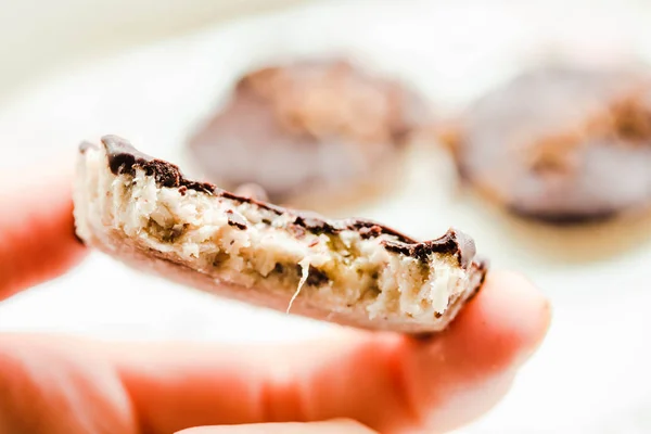 Dulces de coco caseros en chocolate, sosténganse en la mano.Vida sana — Foto de Stock