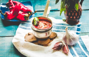 Acı baharatlı domates chili sos sarımsak metal bir fincan fesleğen ile