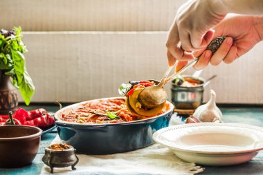 Ratatouille olarak bir m hizmet veren mavi rustik arka plan üzerinde bir çanak çömlek