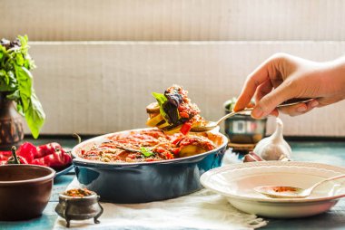 Ratatouille olarak bir m hizmet veren mavi rustik arka plan üzerinde bir çanak çömlek