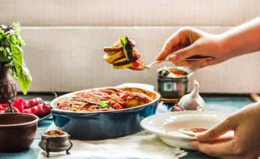 Ratatouille olarak bir m hizmet veren mavi rustik arka plan üzerinde bir çanak çömlek