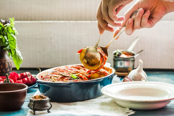 Ratatouille olarak bir m hizmet veren mavi rustik arka plan üzerinde bir çanak çömlek