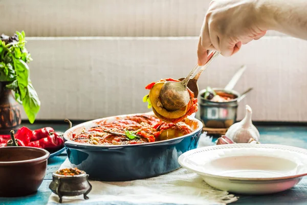 Ratatouille olarak bir m hizmet veren mavi rustik arka plan üzerinde bir çanak çömlek