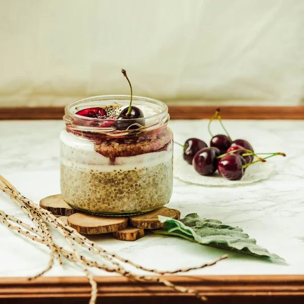 Budín de chía en un frasco con cerezas frescas y coco batido cr — Foto de Stock