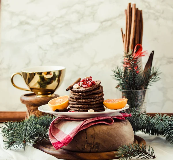 Chocolate banana pancakes with pomegranate and mandarin, winter — Stock Photo, Image