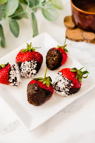 Fresh strawberries dipped in dark chocolate and coconut flakes w — Stock Photo, Image