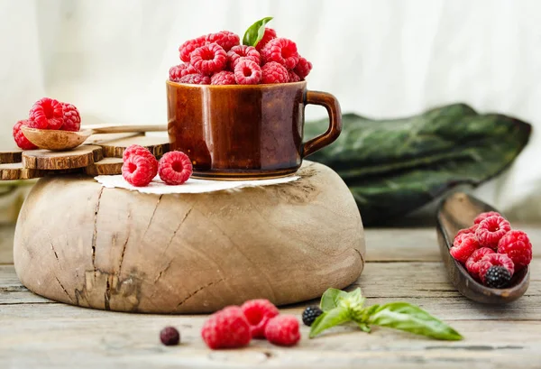 Verse frambozen met basilicum in een kopje koffie en een houten tribune — Stockfoto