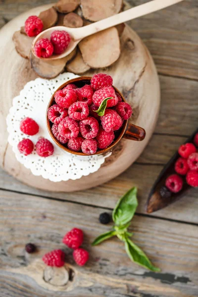 Fresh raspberry with basil in a cup of coffee and a wooden stand — Stock Photo, Image