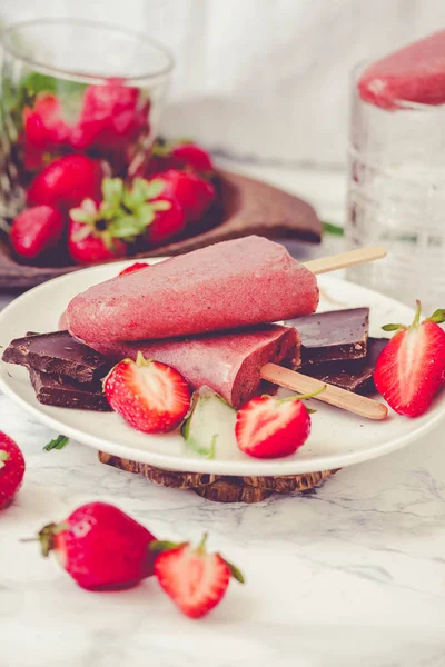 Strawberry ice cream with a banana and chocolate on a stick.Mint — Stock Photo, Image