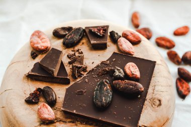 Koyu çikolata parçaları ezilmiş ve kakao çekirdekleri, ahşap su üzerinde Hazretleri