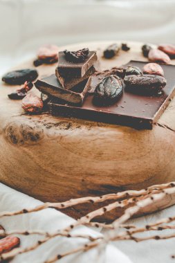 Koyu çikolata parçaları ezilmiş ve kakao çekirdekleri, ahşap su üzerinde Hazretleri