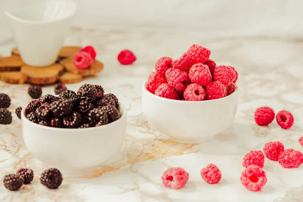 Frambuesas crudas y negras silvestres, moras en tazas blancas. Ligh. —  Fotos de Stock