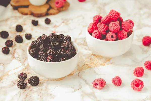 Frambuesas crudas y negras silvestres, moras en tazas blancas. Ligh. —  Fotos de Stock