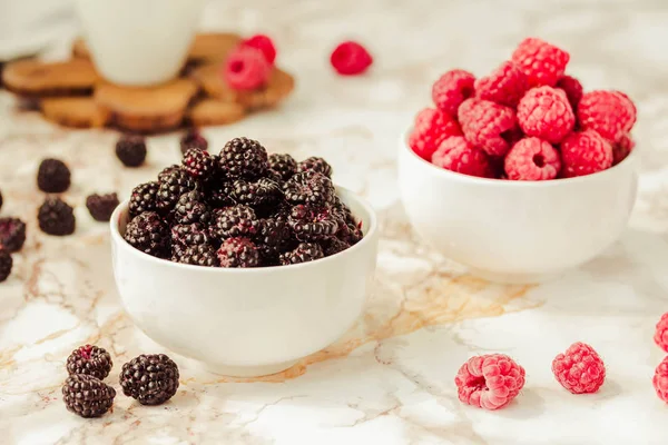 Frambuesas crudas y negras silvestres, moras en tazas blancas. Ligh. —  Fotos de Stock