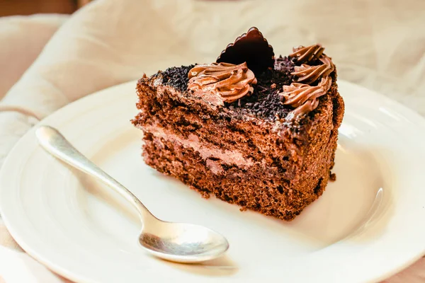 A slice of delicious chocolate cake on a white linen tablecloth. — 스톡 사진