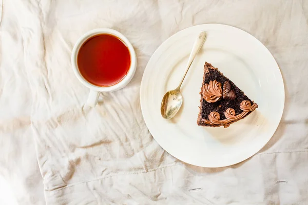 Teller mit Scheibe leckeren hausgemachten Schokoladenkuchen auf weißem Blech — Stockfoto