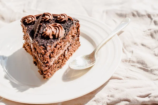 Freshly made delicious chocolate cake on a white linen tableclot — Stock Photo, Image