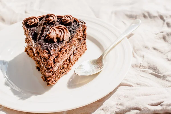 Pastel de chocolate delicioso recién hecho en una mesa de lino blanco — Foto de Stock