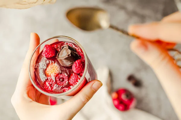 Young woman hands holding Sweet cold red jelly with berries and — Stockfoto