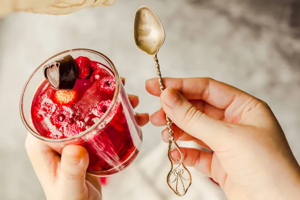 Young woman hands holding Sweet cold red jelly with berries and — ストック写真