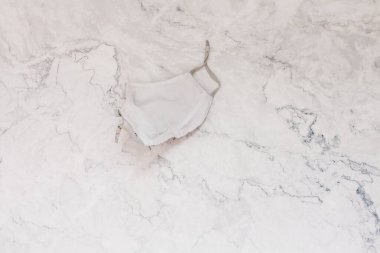 Güzel bir yüz maskesi. Bej doğal renk. Mermer zemin üzerinde solunum bandajı yüz. Virüsün yayılmasını önlemek ve salgın COVID-19.