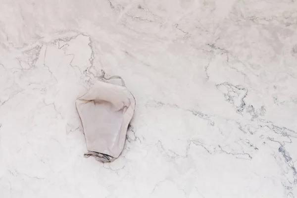 Mooie Stof Gezichtsmasker Beige Natuurlijke Kleur Ademhalingsverband Gezicht Marmeren Achtergrond — Stockfoto
