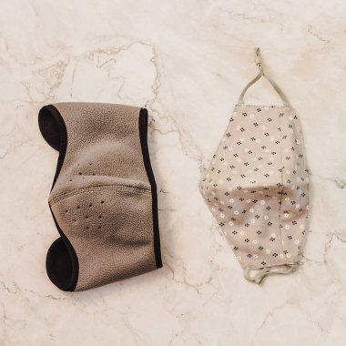 Güzel bir yüz maskesi. Bej doğal, gri ve mavi renk. Mermer zemin üzerinde solunum bandajı yüz. Tıbbi solunum bandajı suratı. Virüs ve salgın hastalığın yayılmasının önlenmesi. Uzayı kopyala