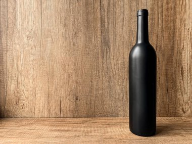Ahşap arka planda kırmızı şarap şişesi.